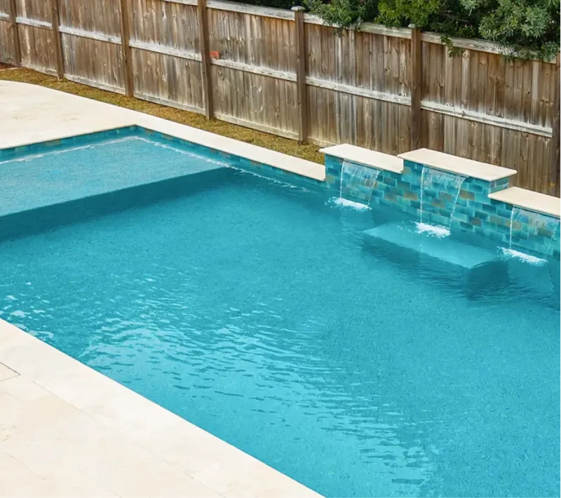 Swimming pool upgrade by Legacy Pools featuring a raised water feature wall with three spillways and decorative teal tile.