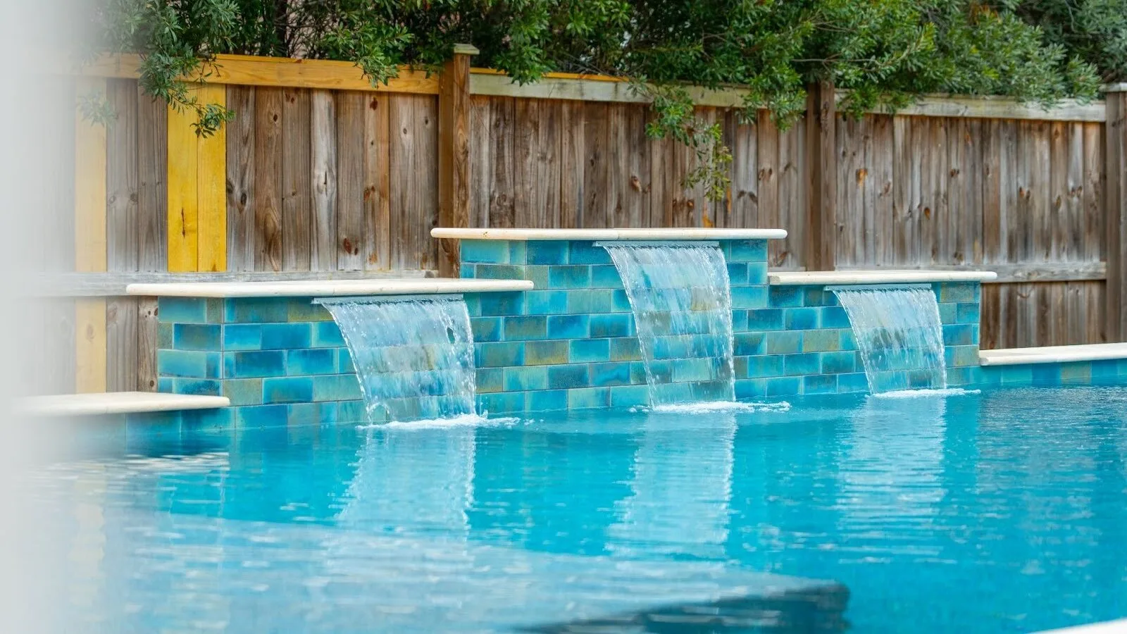 Custom-designed backyard swimming pool with elegant finish, surrounding patio, and landscaped outdoor living space.