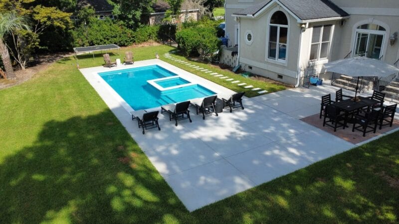 An aerial view of a backyard with a pool and grass