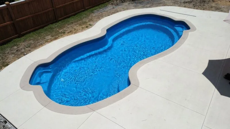 An oblong-shaped pool in a backyard