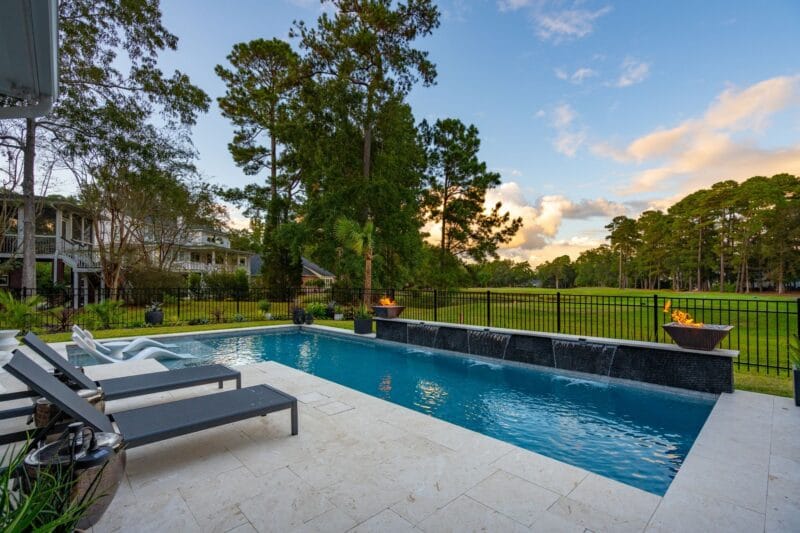 A beautiful backyard gunite pool with the sunset in the background