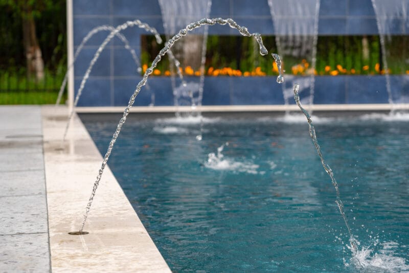Fiberglass pool spouts with fire in the background