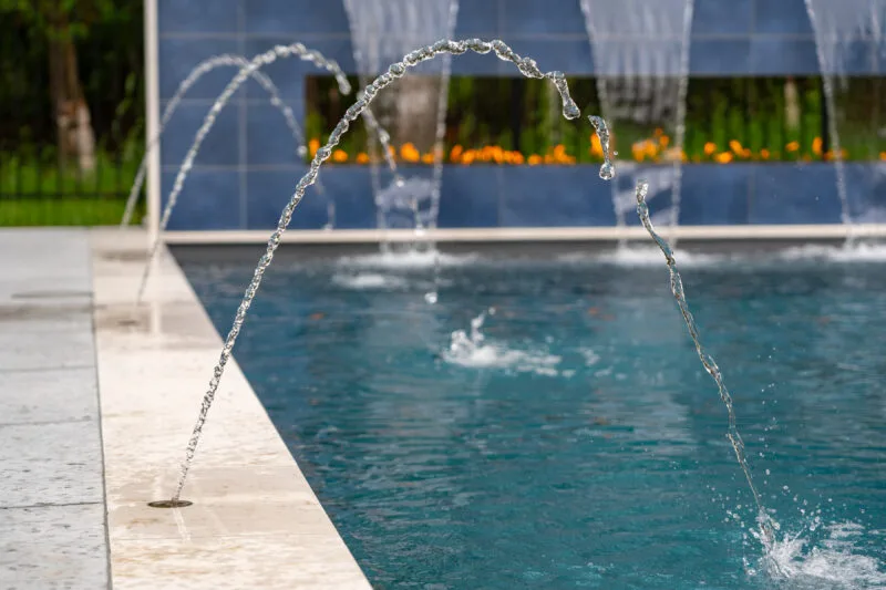 Fiberglass pool spouts with fire in the background