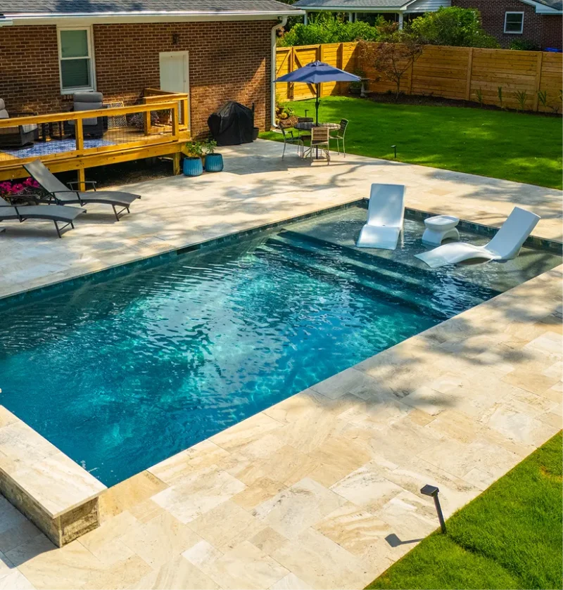 A backyard remodeled pool with turquoise water