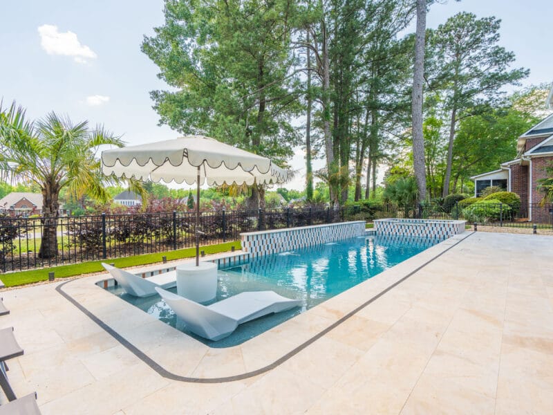 Club Course drive gunite swimming pool build with an umbrella nearby