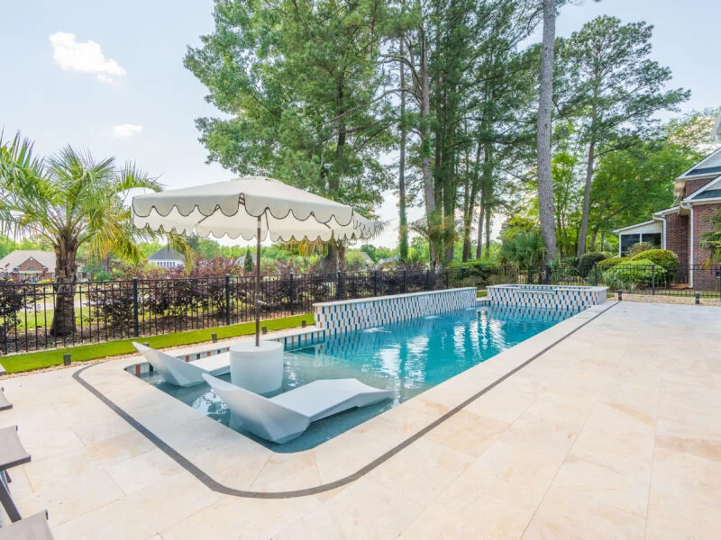 Club Course drive gunite swimming pool build with an umbrella nearby