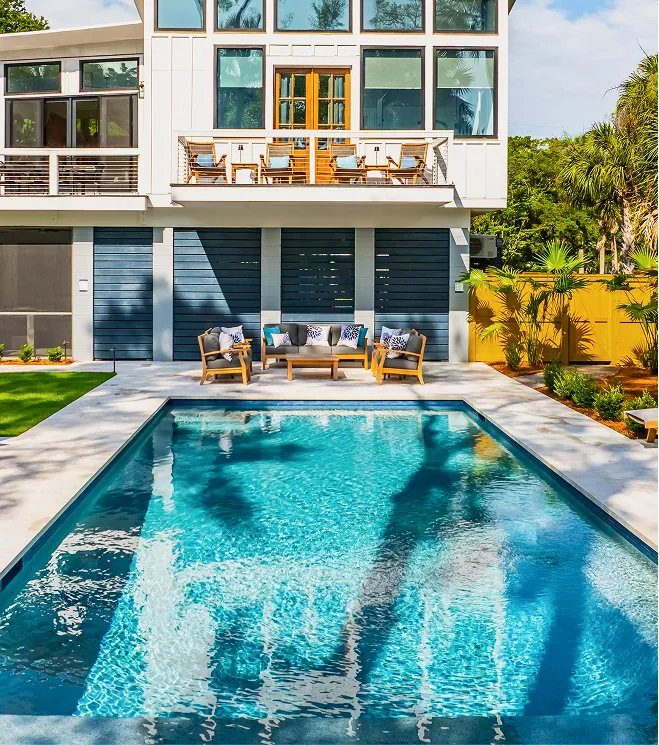 A remodeled pool in a backyard of a two-story home